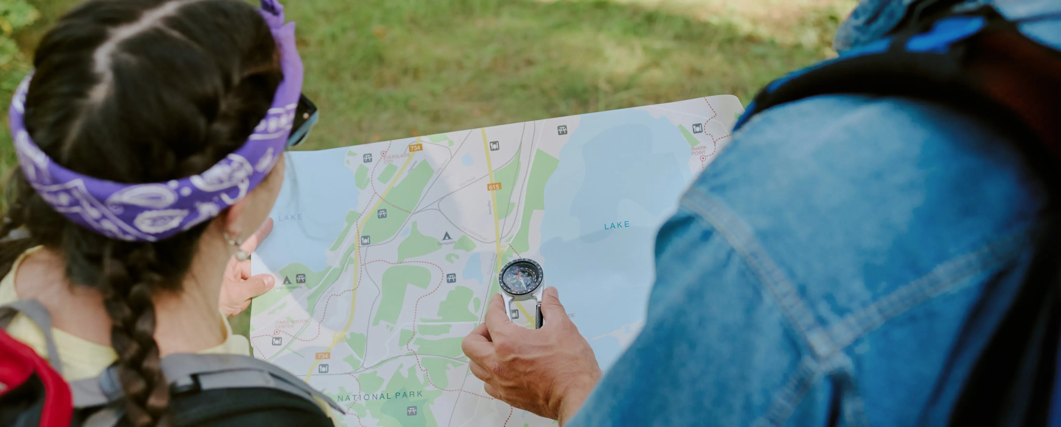 two people looking at a map with a compass.