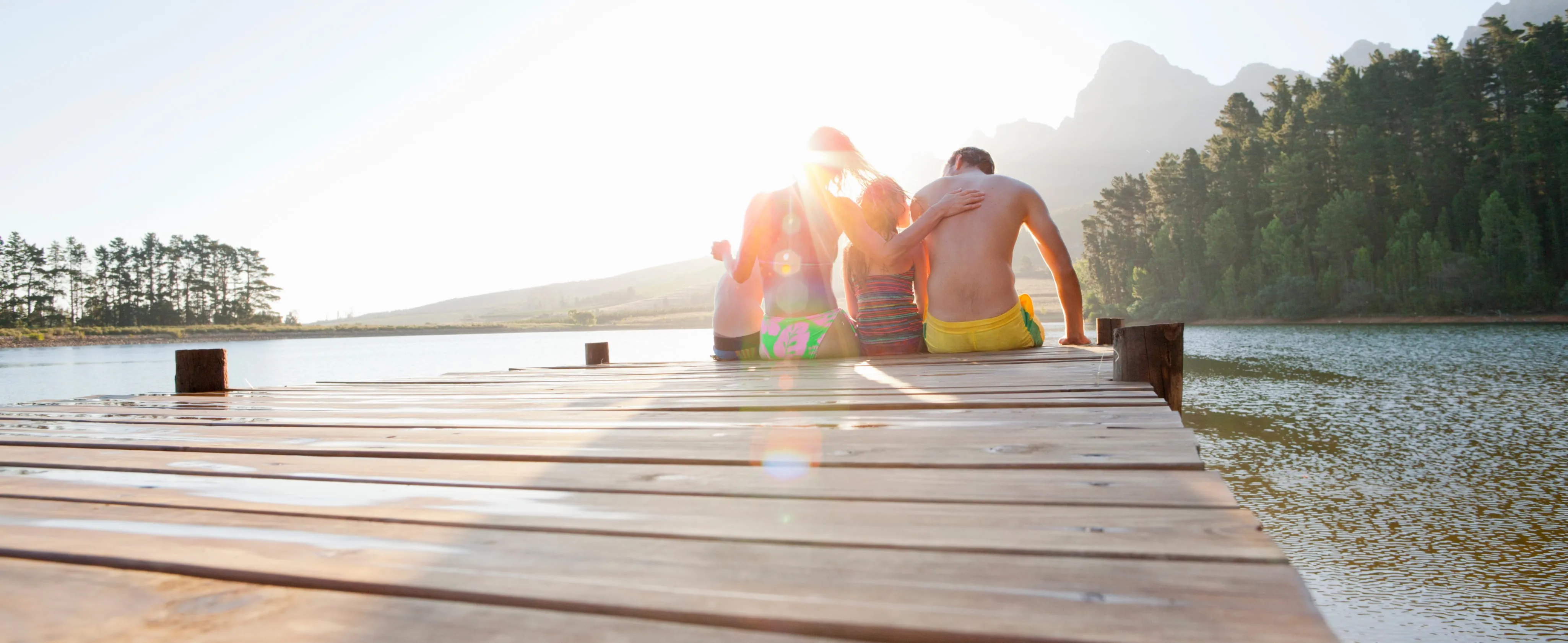 a family sitting off the end of a dock