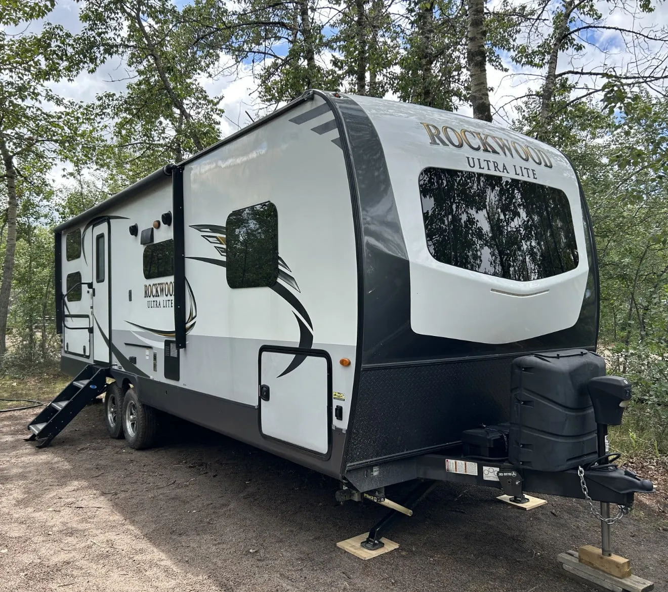 a RV all setup in a camp site ready to be used.
