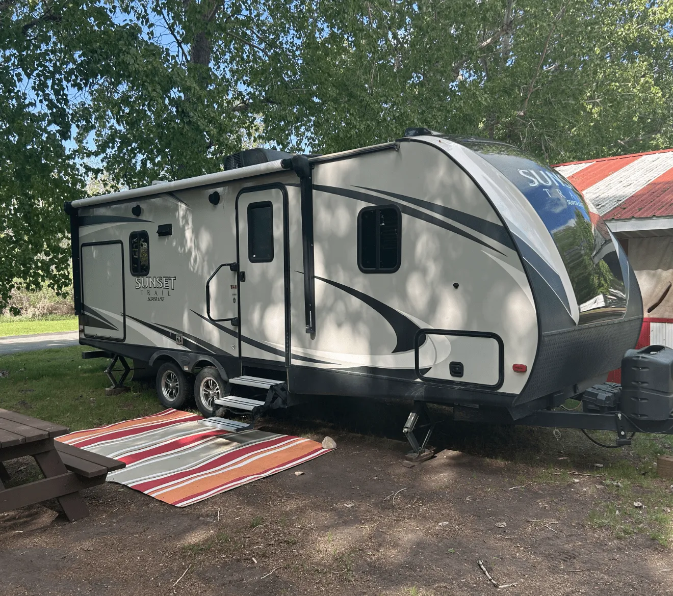 a RV all setup in a camp site ready to be used.
